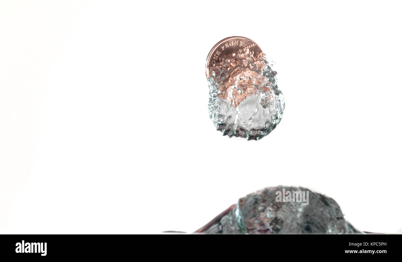 Münze Planschen im Wasser mit hoher Geschwindigkeit Fotografie, auf einem weißen Hintergrund gefangen Stockfoto