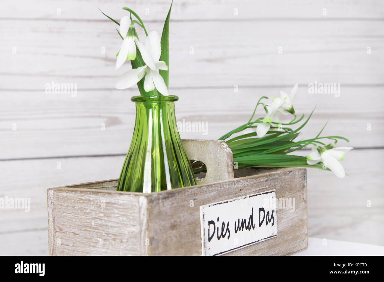 Lilie des Tages in grüner Vase und Holzkiste vor einer Holzwand im Shabby Chic Stockfoto