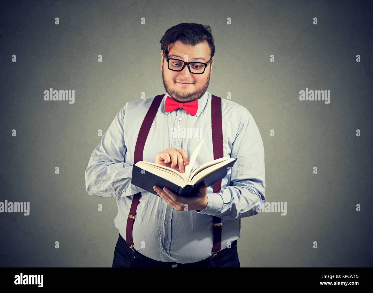 Inhalt Mann in Brillen lesen interessante Buch suchen etwas erstaunt. Stockfoto