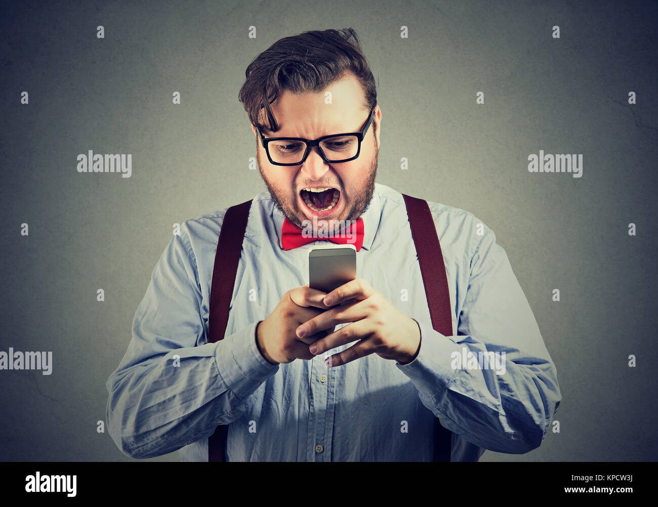 Beleibte Mann schrie Smartphone extrem verärgert. Stockfoto