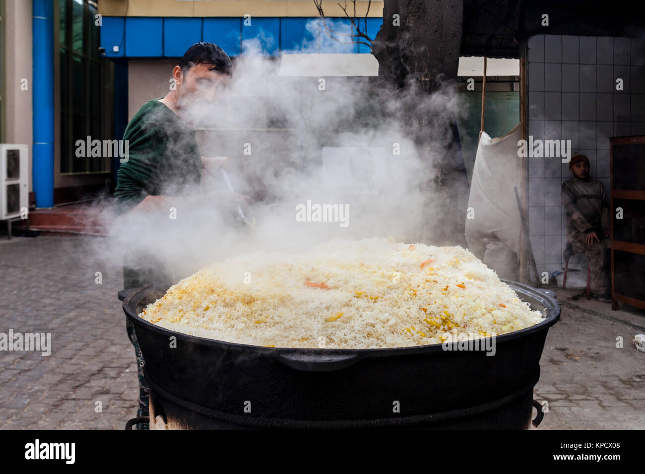 Ein Mann kocht Reis für PLOV (Nationalgericht) An der Zentralasiatischen Plov Center, Taschkent, Usbekistan Stockfoto