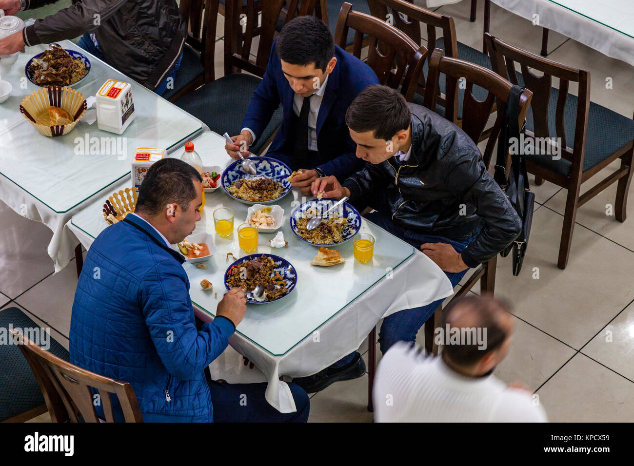 Usbekische Männer essen PLOV (Nationalgericht) An der Zentralasiatischen Plov Center, Taschkent, Usbekistan Stockfoto