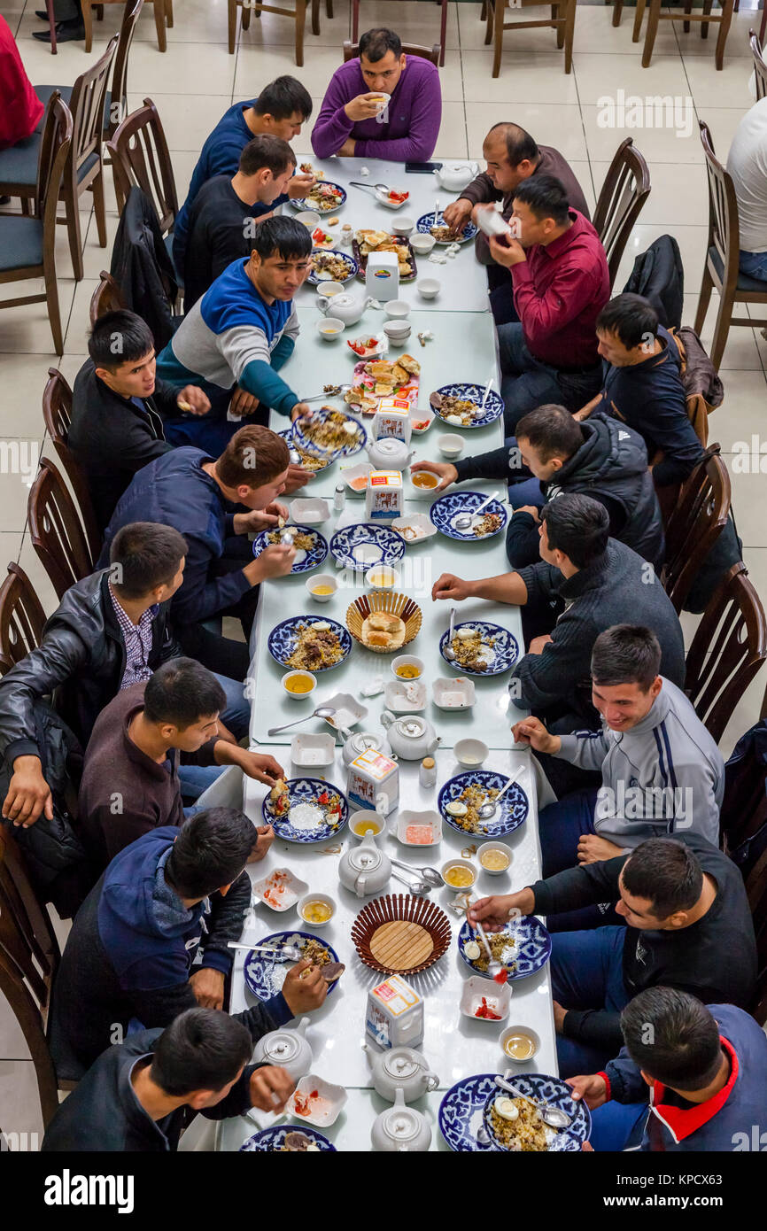 Eine große Gruppe von usbekischen Männer essen PLOV (Nationalgericht) An der Zentralasiatischen Plov Center, Taschkent, Usbekistan Stockfoto