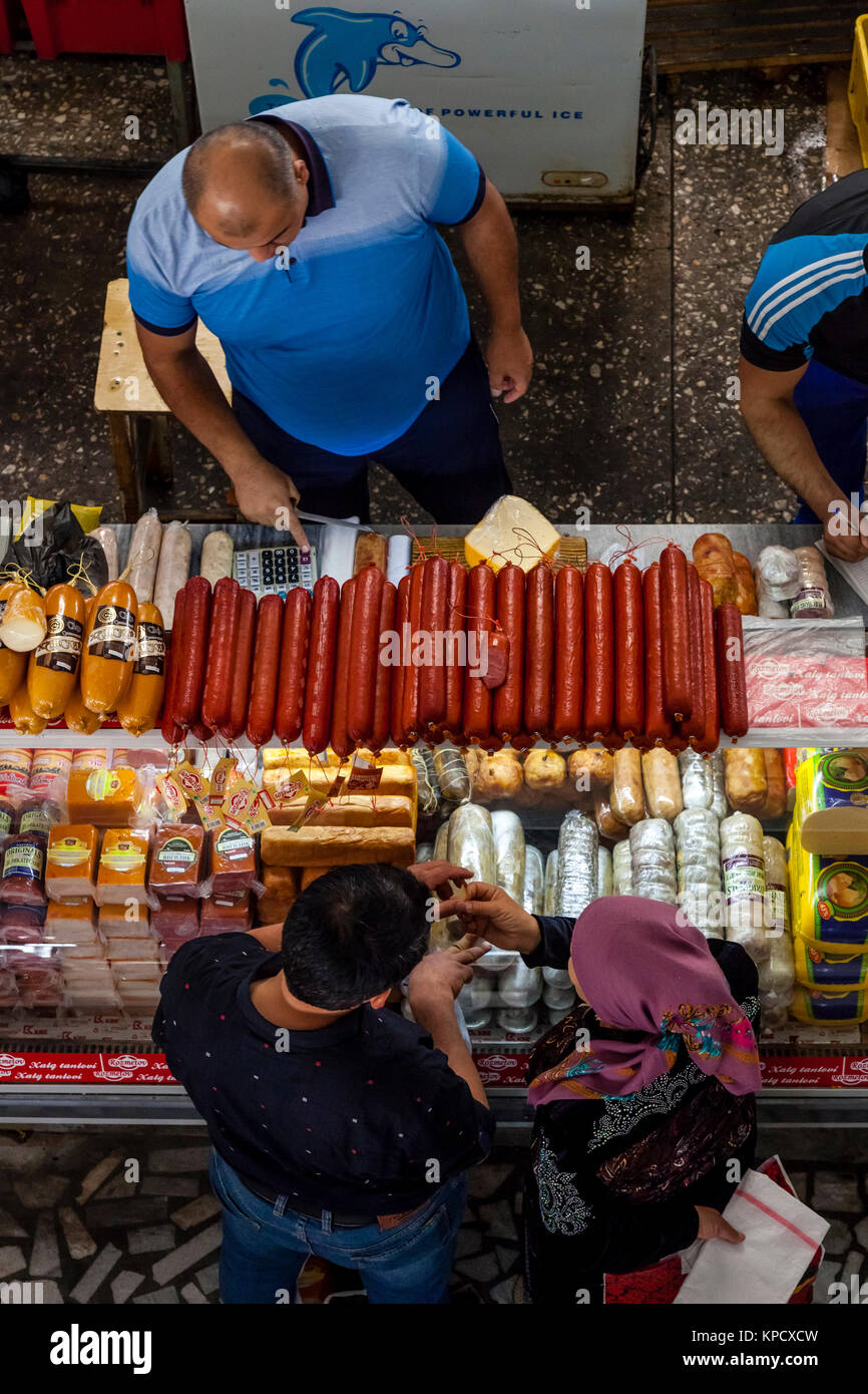 Ein Mann verkauft von Fleischerzeugnissen aus einem Stall in Chorsu-basar, Taschkent, Usbekistan Stockfoto