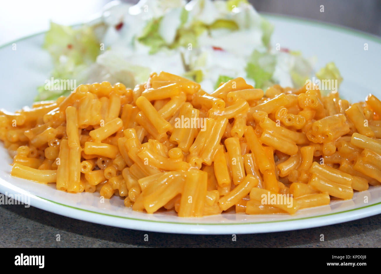 Teller Makkaroni und Käse mit einem Beilagensalat - eine schnelle und einfache Mahlzeit Stockfoto