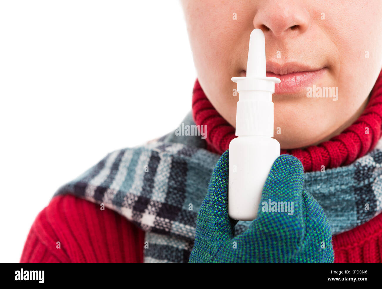 Kalte Frau mit Nasenspray oder halten Sie es in der Nähe der Nase tragen warme Kleidung mit Schal und Handschuhe Stockfoto