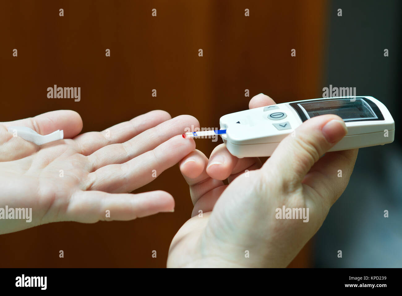 Blutzucker- Gerät ist in weiblichen Händen, während Blutprobe durchgeführt wird, Blutprobe wird durch spezielle Gerät aus menschlichen Finger genommen. Russland, Volgogra Stockfoto Blutzucker- Gerät ist in weiblichen Händen, während Blutprobe durchgeführt wird, Blutprobe wird durch spezielle Gerät aus menschlichen Finger genommen. Russland, Volgogra Stockfoto