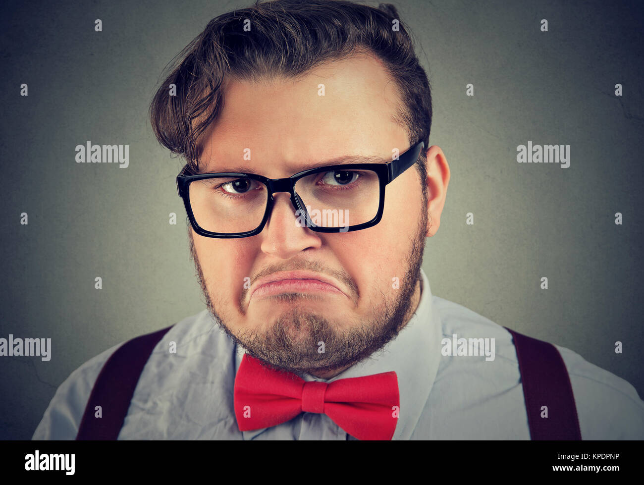 Headshot von mollig Mann in Rot bowtie und Gläser an Kamera suchen mit Expression von Unmut. Stockfoto