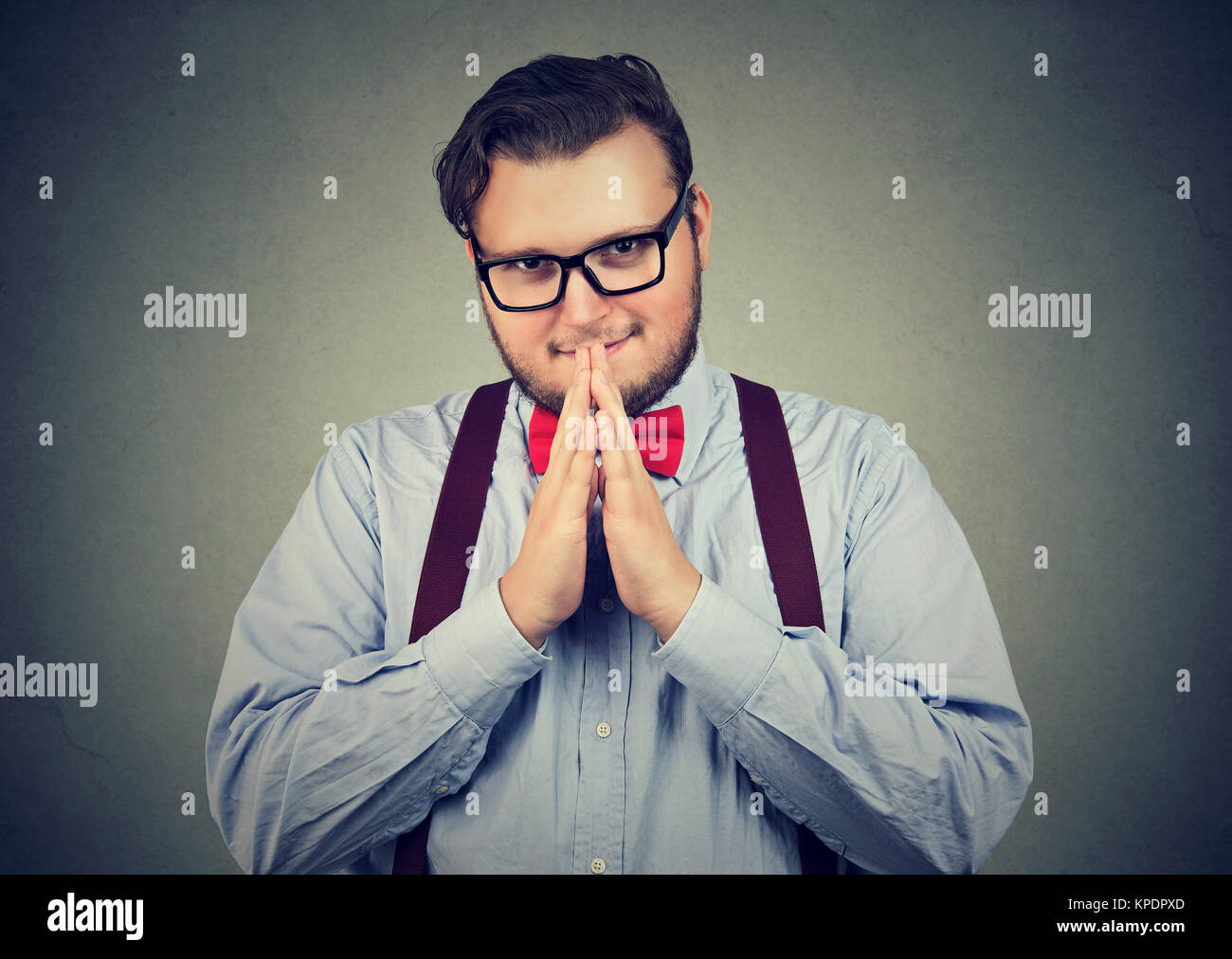 Chunky Mann in Brillen Hände zusammen halten an Kamera und Rache planen Suchen listig. Stockfoto