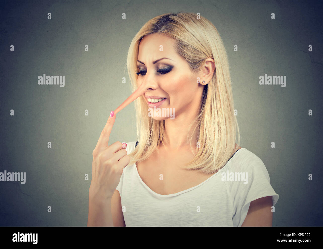 Junge Frau in verlängerte Nase von kreativen Lügner posiert auf Grau. Stockfoto