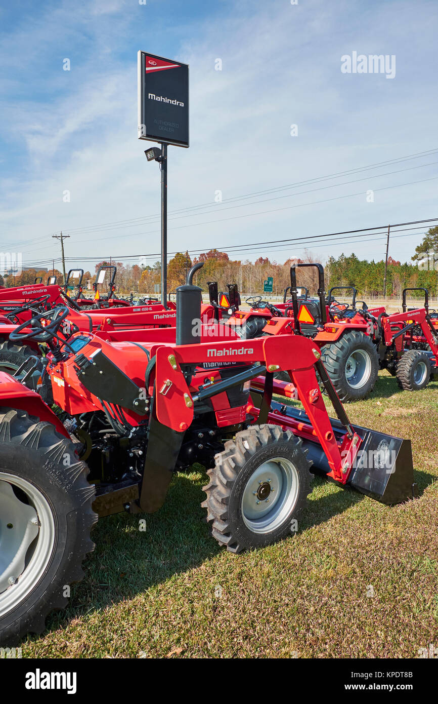 Mahindra Händler anmelden oder Signage steht über Reihen von neuen roten Mahindra Farm und Bau, alle Traktoren zum Verkauf. Stockfoto