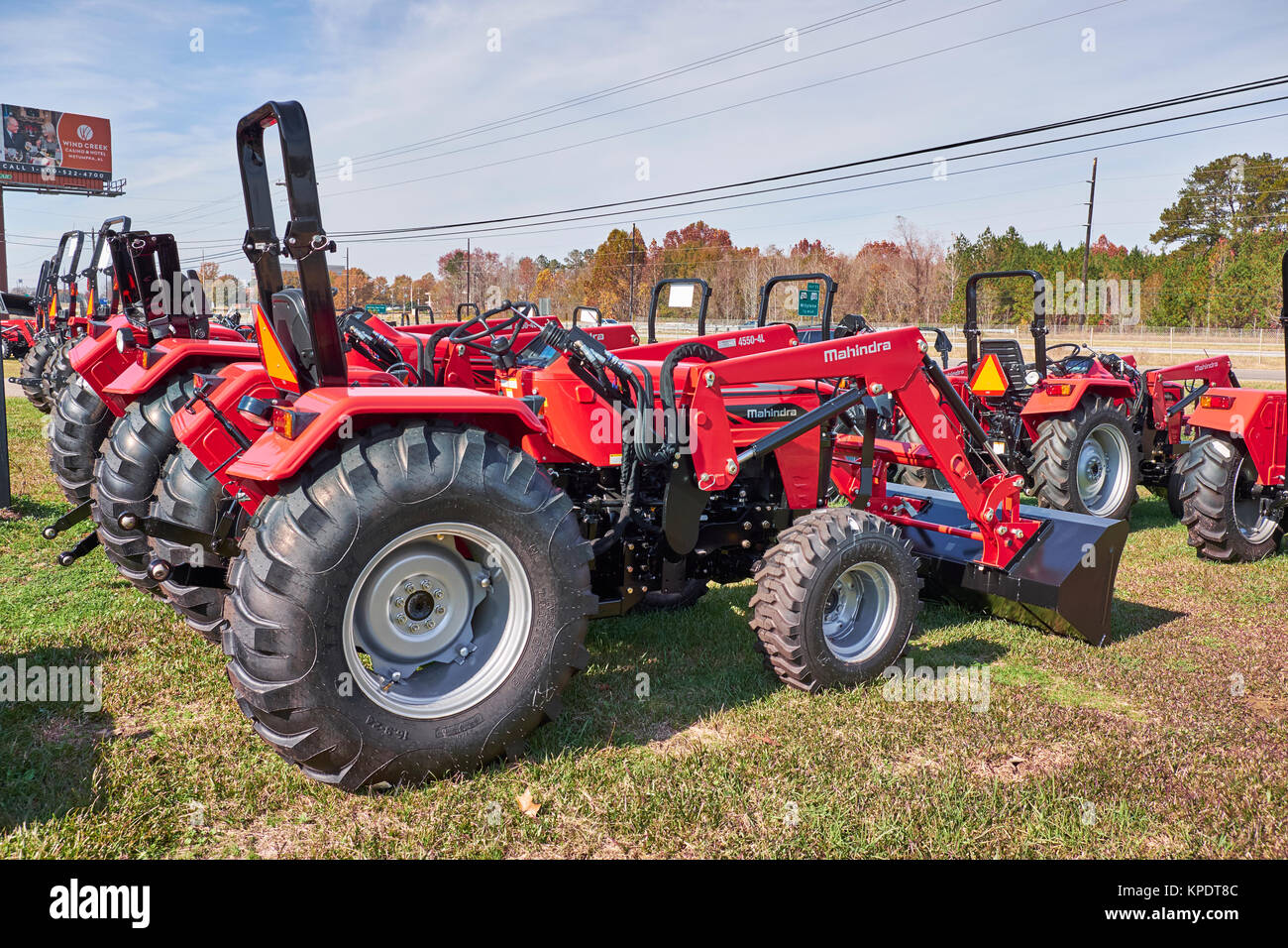 Reihen von neuen Mahindra roten Traktoren und landwirtschaftlichen Maschinen zum Verkauf an einer Mahindra Traktor Händler, teilweise mit Sonderausstattungen. Stockfoto