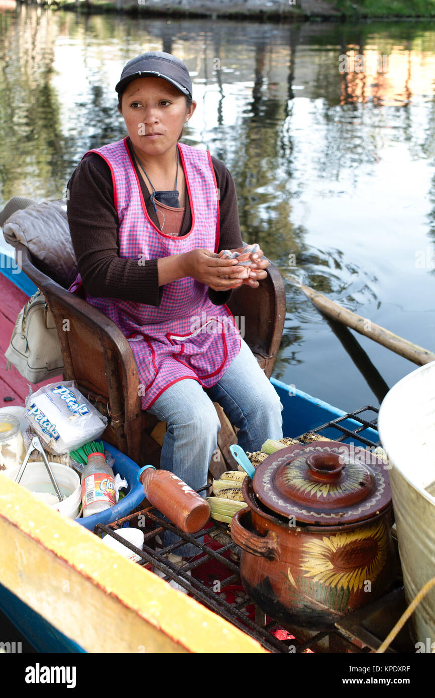 Xochimilco, Mexiko City, Mexiko - 2017: eine Frau in atrajinera (ein lokaler Art des Bootes) verkauft lokales Essen von Menschen in anderen trajineras auf Stadt canal Stockfoto