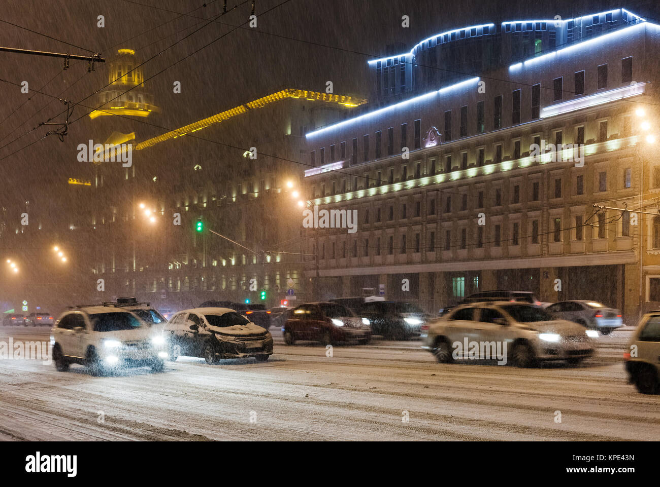 Autos fahren unter Schnee auf night street Stockfoto