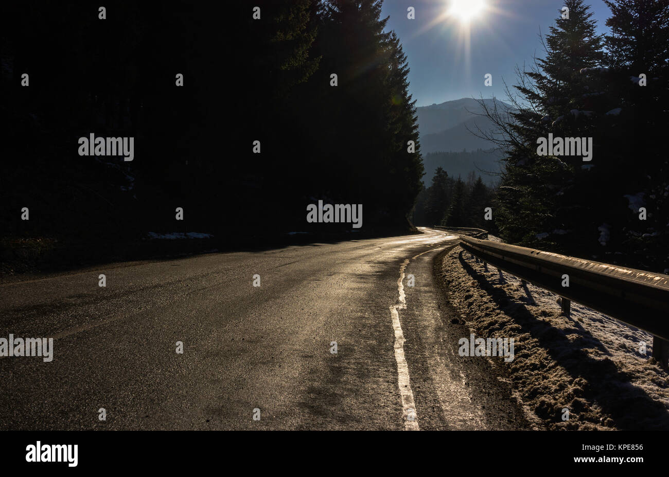 Eine glänzende Straße Kurve in die Vogesen im Winter mit Sonnenschein, Frankreich. Stockfoto