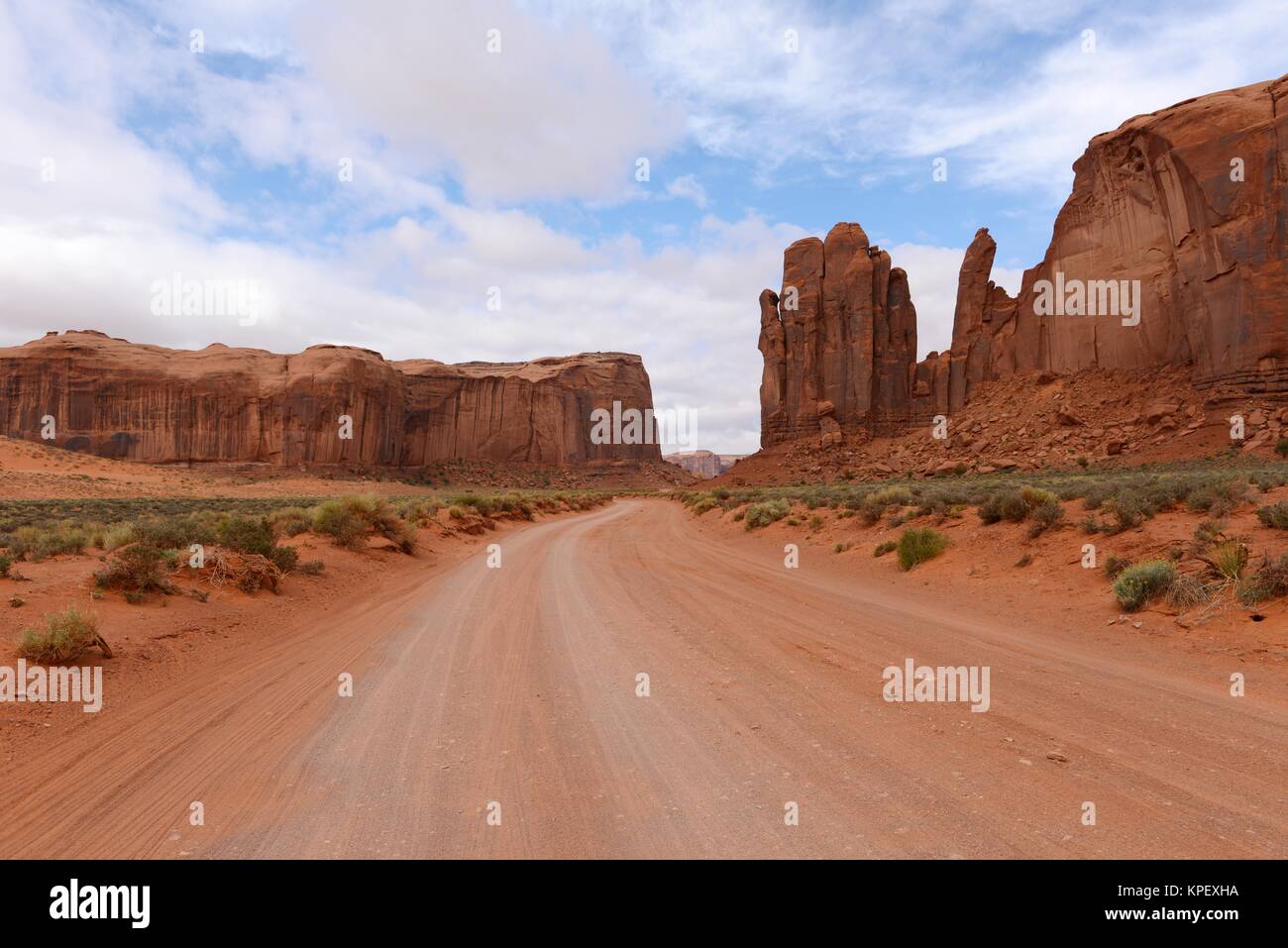 Die rote Wüste Valley Road - eine unbefestigte Piste windet sich durch rote Sandstein Wüstental in der berühmten Monument Valley, Utah und Arizona, USA. Stockfoto