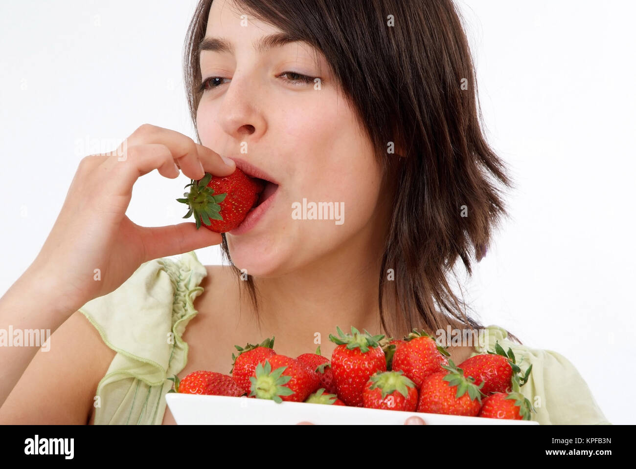 Junge Frau Isst Erdbeeren - junge Frau isst Erdbeeren Stockfoto