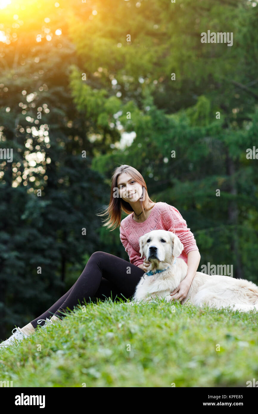 Bild von Unten Der sitzende Frau mit Hund auf dem grünen Rasen Stockfoto