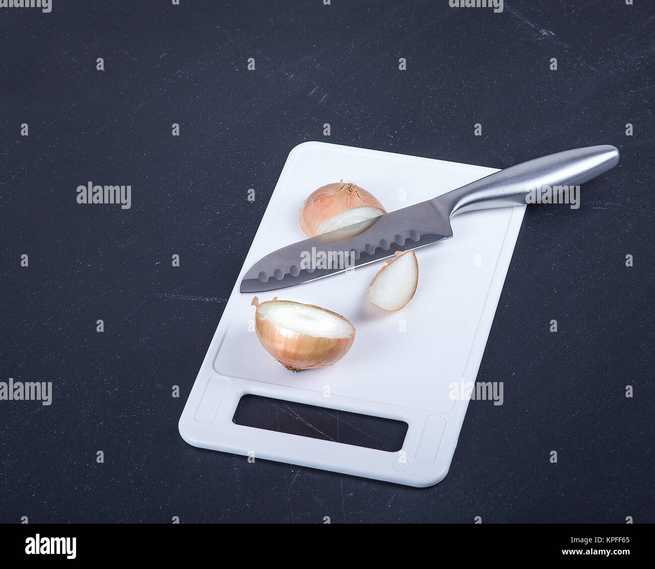 Edelstahl Kochmesser und Zwiebel auf ein Schneidebrett. Stockfoto