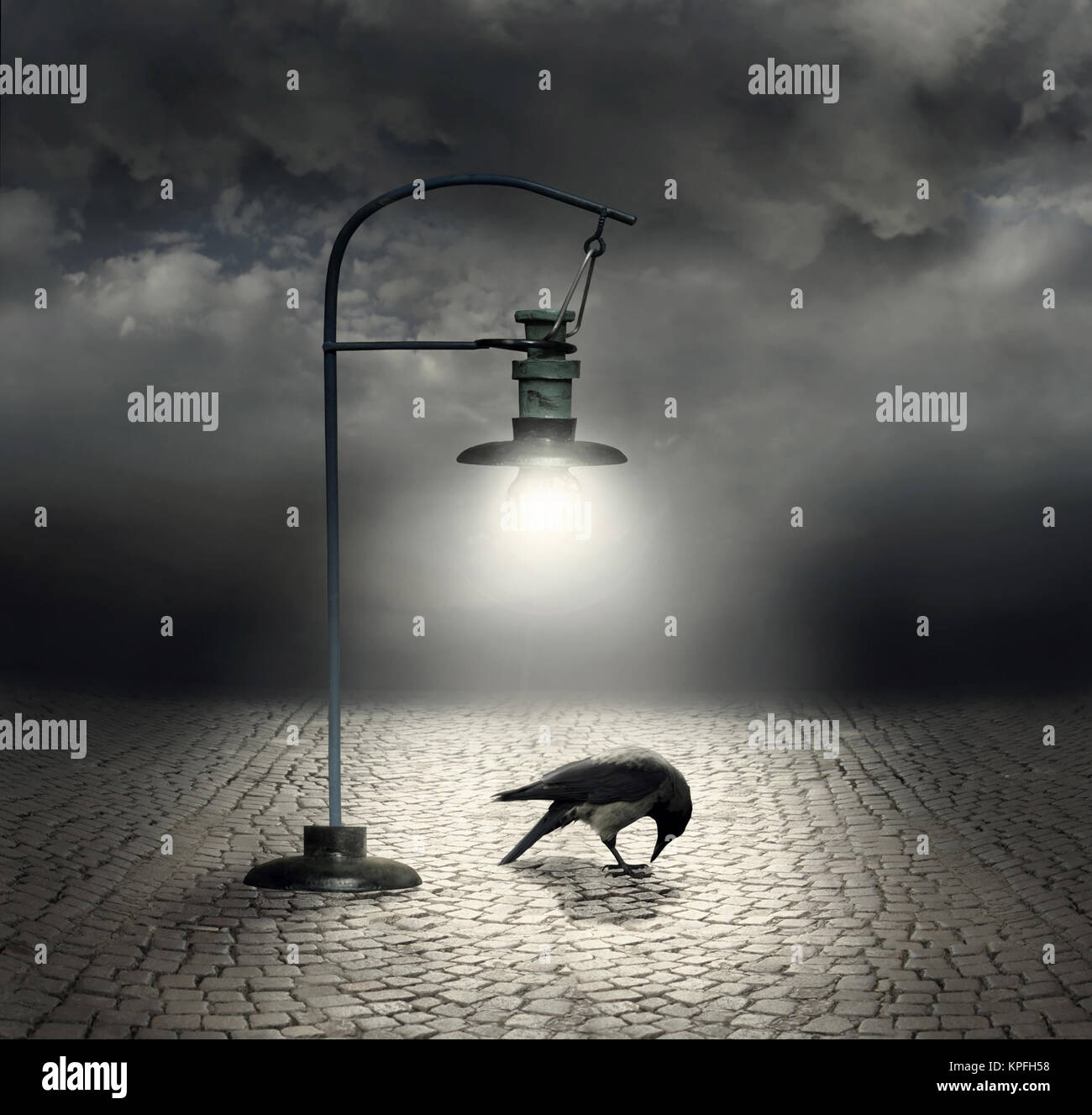 Schöne künstlerische Bild mit einer Straßenlaterne, die aufleuchtet, eine Krähe und Kopfsteinpflaster mit einem dunklen und bewölkter Himmel im Hintergrund Stockfoto