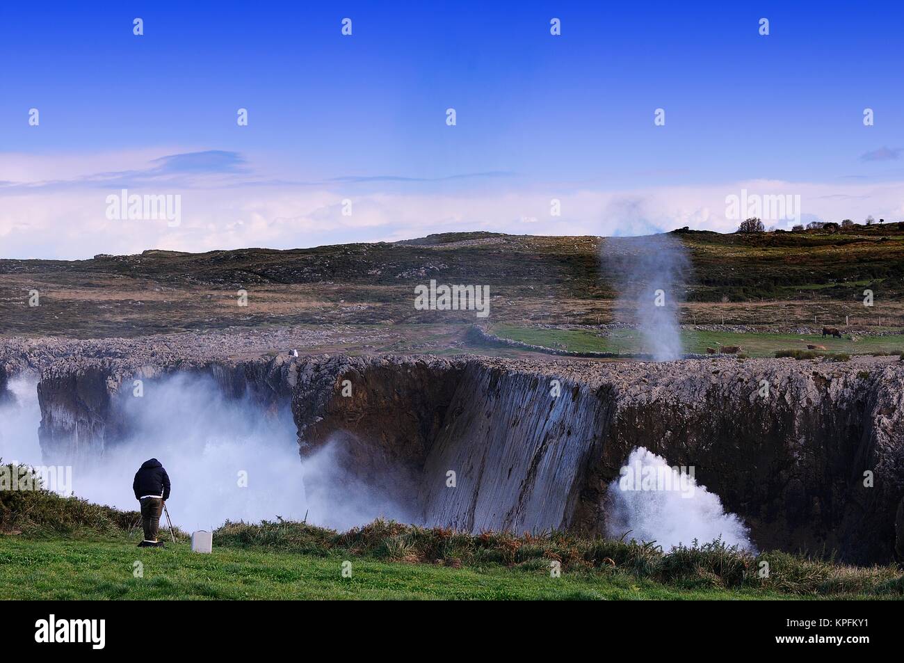Bufones de Pria an der Küste in der Nähe von einer Klippe in Asturien, Spanien. Ein Fotograf nimmt Bilder der Szene. Stockfoto