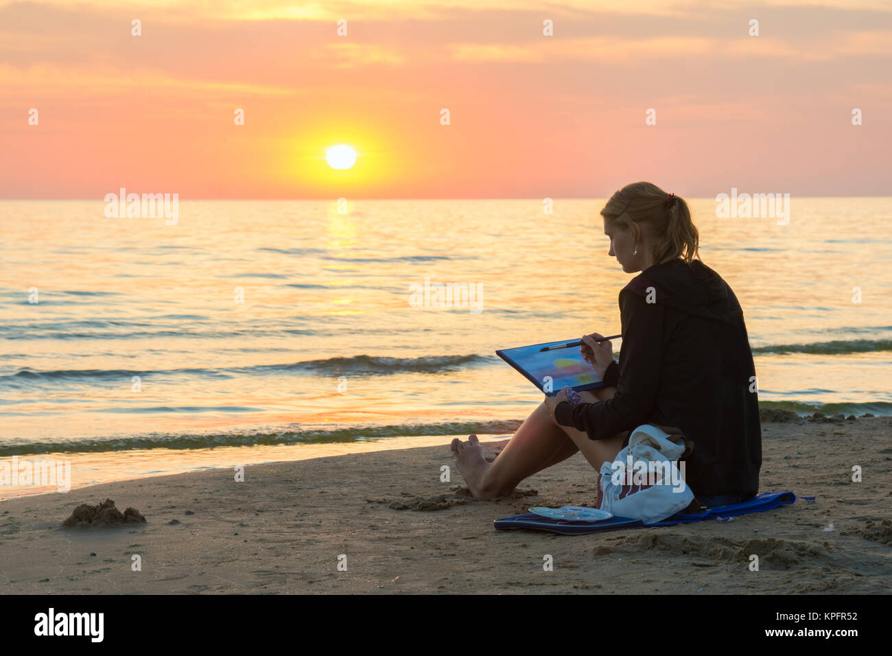 Junges Madchen Am Strand Sitzen Und Zeichnen Sie Auf Einem Blatt Aquarell Sonnenuntergang Stockfotografie Alamy