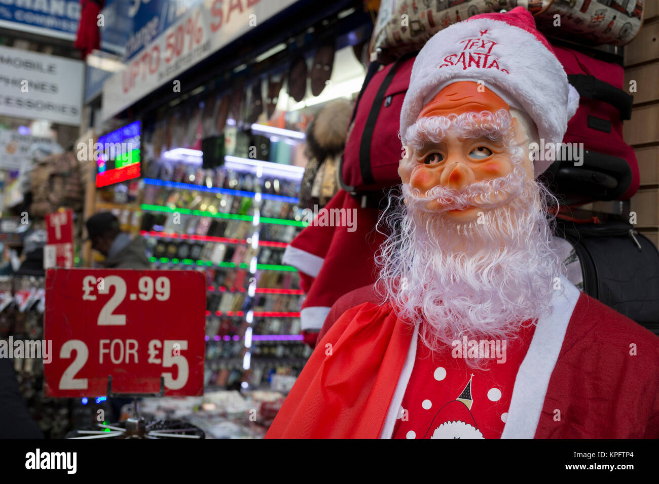 Die furchtsamen Augen eines santa Peers durch die Maske, da er nicht in einen Haushalt shop für Schmuckstücke in der Oxford Street steht, am 12. Dezember 2017 in London, England. Stockfoto