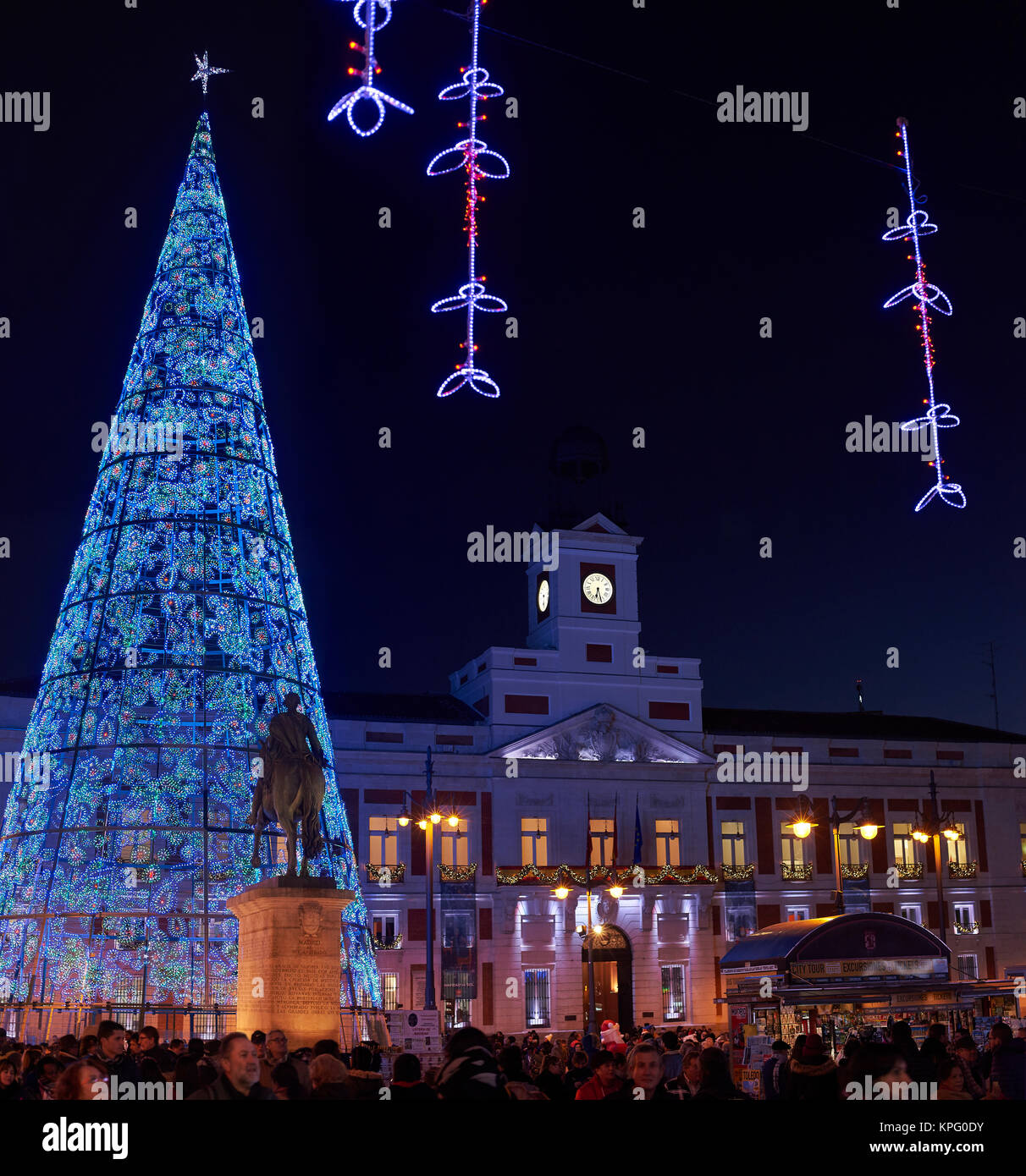Madrid, Spanien - 12. Dezember 2017. Puerta del Sol Platz bei Einbruch der Dunkelheit durch die Weihnachtsbeleuchtung und ein glänzender Weihnachtsbaum mit Real Casa de Co beleuchtet Stockfoto