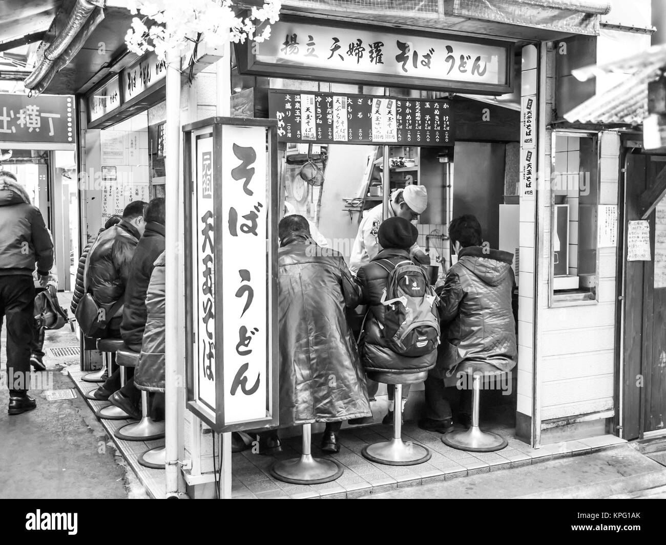 Tokyo, Japan - 19. Februar 2014: eine Gruppe von Männern in einem kleinen izakaya (bar) in einer kleinen Gasse von Shinjuku, Tokyo essen. Stockfoto