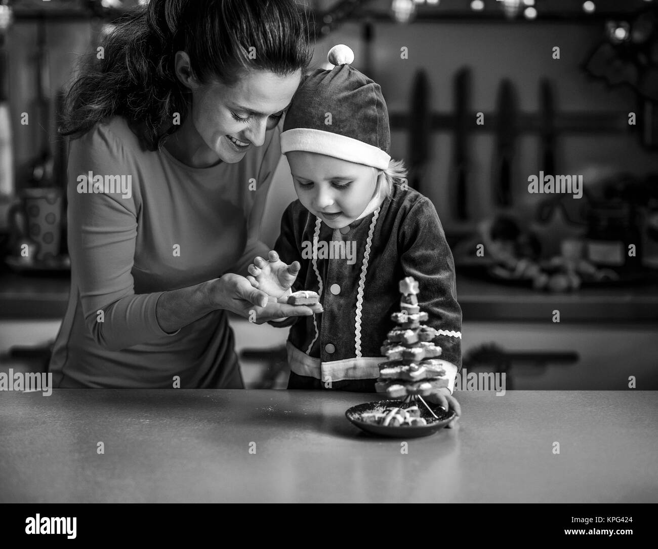 Glückliche Mutter und Baby machen Weihnachtsbaum von cookies Stockfoto