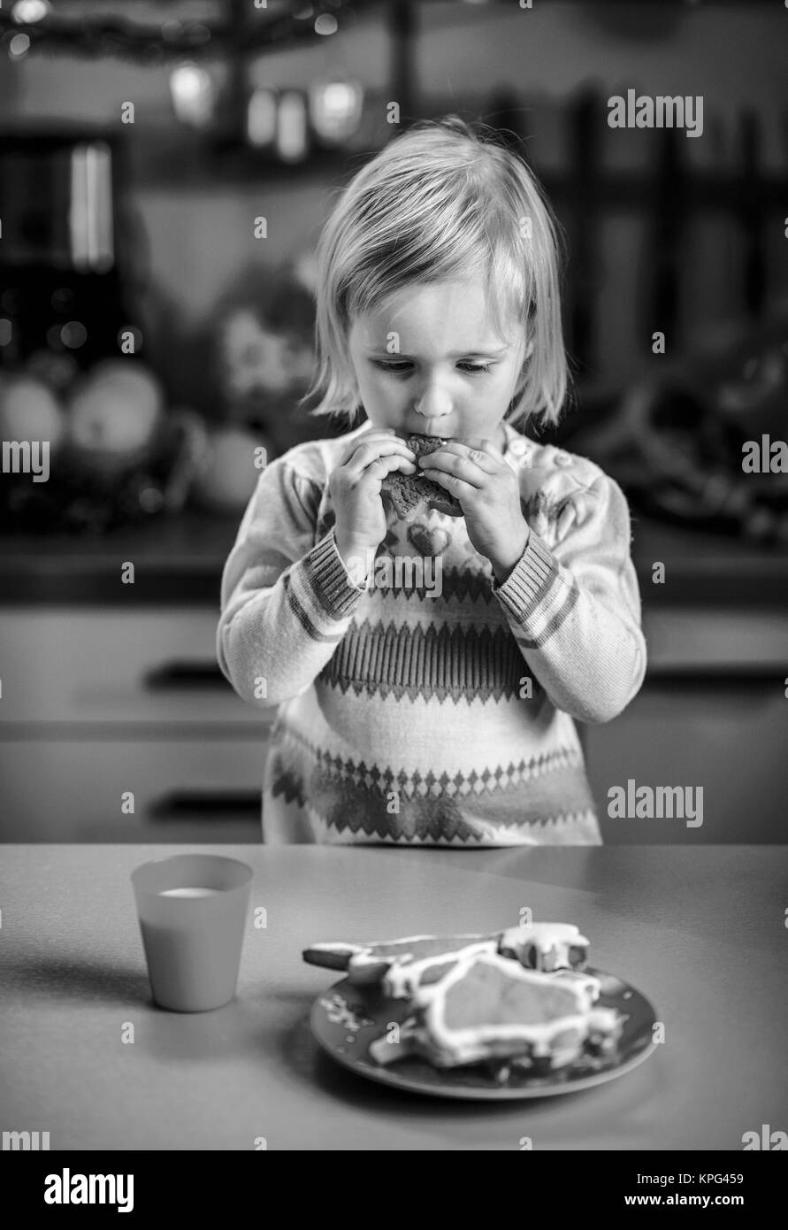 Baby Verkostung in Weihnachten dekoriert Küche hausgemachte Weihnachtskekse Stockfoto