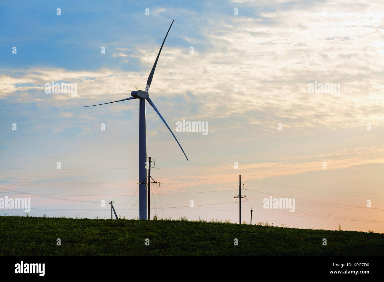Mühle für elektrische Energie gegen Sonnenuntergang Himmel. Erneuerbare elektrische Energie. Windenergieanlage eine nachhaltige Energie. Stockfoto