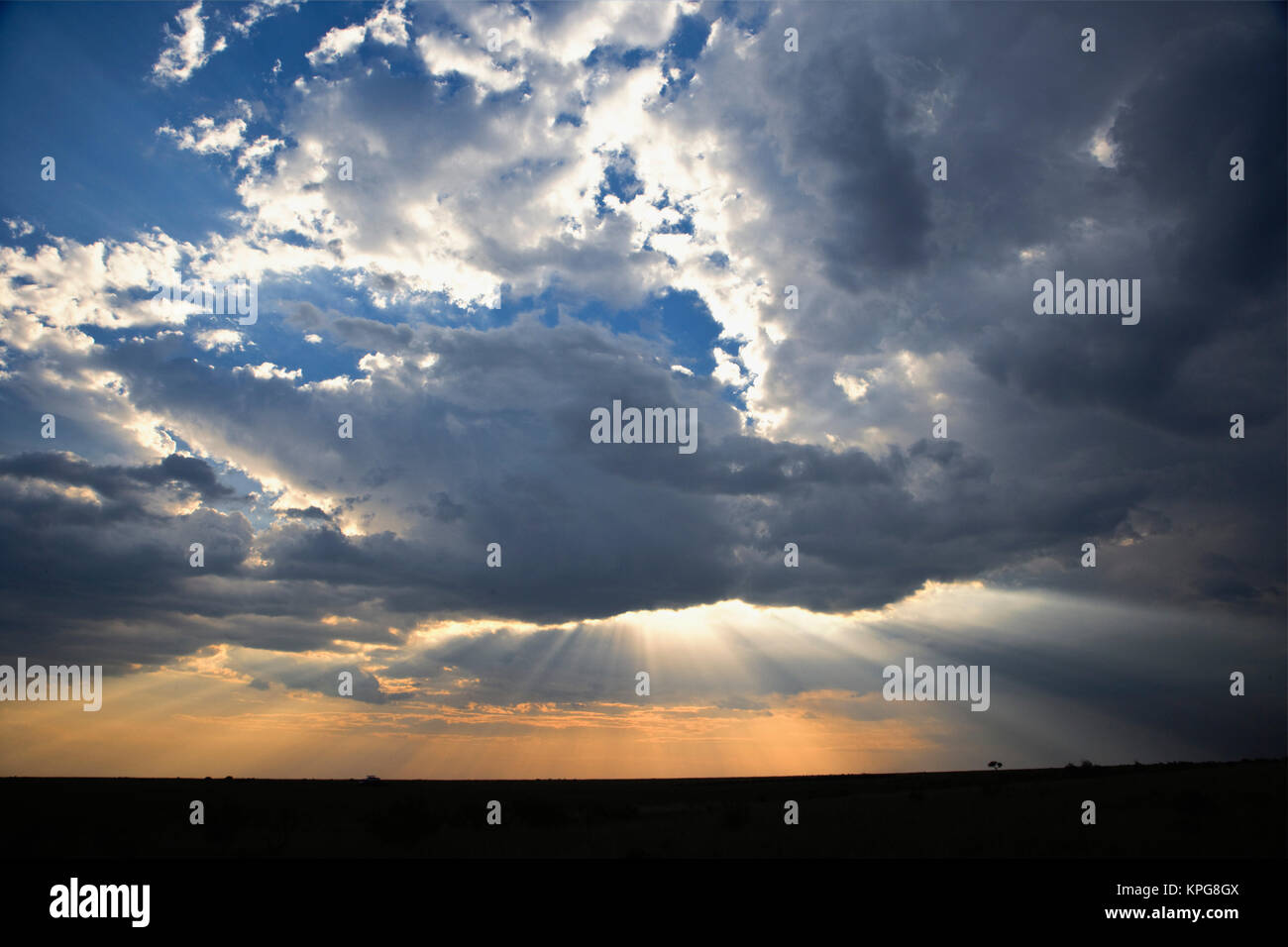 Sunbeams Streaming durch Wolken, Masai Mara, Kenia Stockfoto