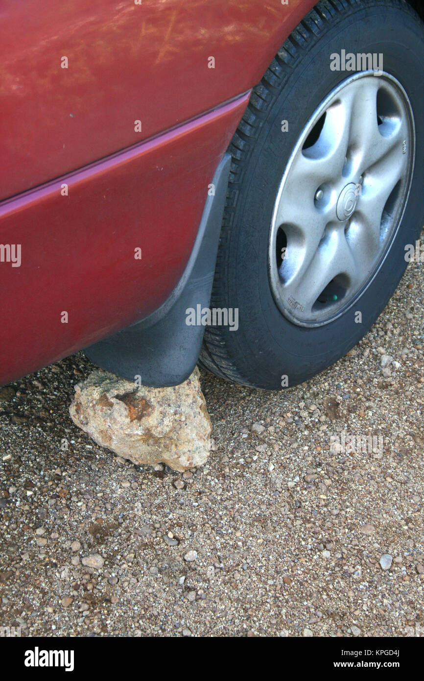 Nahaufnahme des geparkten Autos mit Stein hinter ein Rad, Südafrika Stockfoto