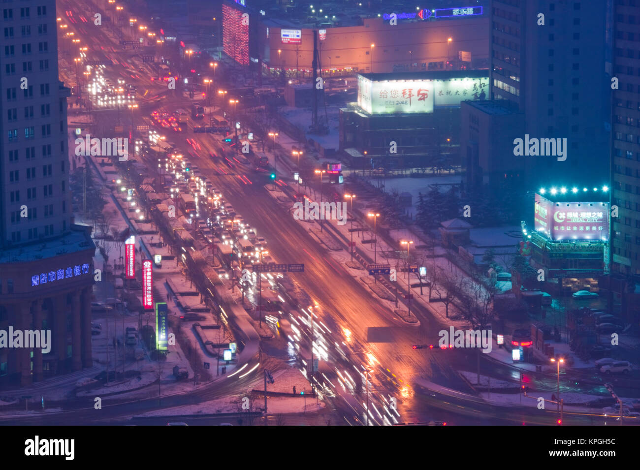 China, Provinz Shandong, Jinan. Qingdao Neue Stadt - Luftaufnahme von Rush Hour Traffic auf xianggang Zhonglu mit Schnee / Abend. Stockfoto