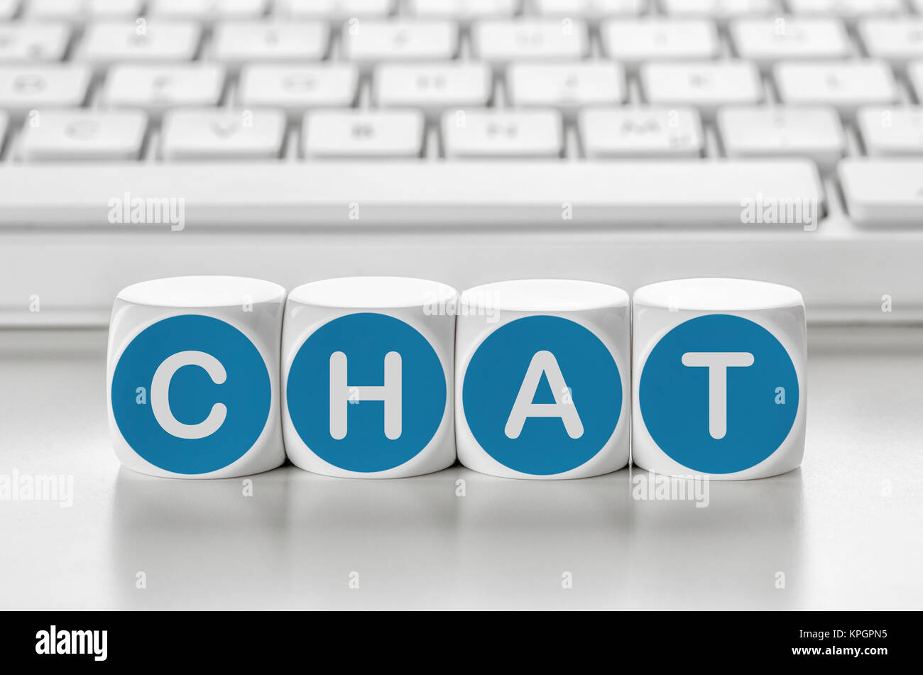 Buchstabenwürfel vor einer Tastatur-Chat Stockfoto