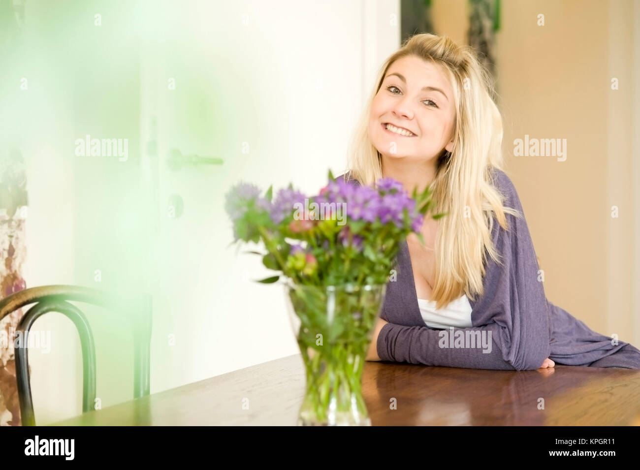 Model Release, Junge, Froehliche Frau, 24, Sitzt Gemuetlich am Tisch - Frau Beeing am Tisch Stockfoto