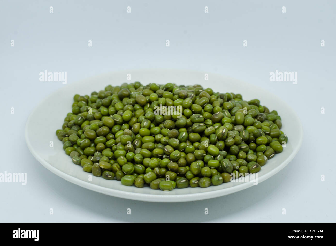 Mung Bohnen in der Platte auf weißem Hintergrund. Auch als moong Bean bekannt, grünes Gramm grüne Bohne. Seine in Leguminosen Familie Arten Stockfoto
