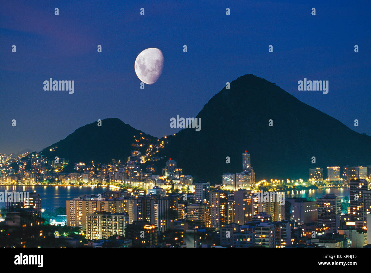 Brasilien, Rio de Janeiro, Double Exposure der Mond über Lagoa Rodrigo de Freitas See bei Nacht von oben auf der Rua Do Mirante Penhasco Apanena, Dois Irmaos. Stockfoto