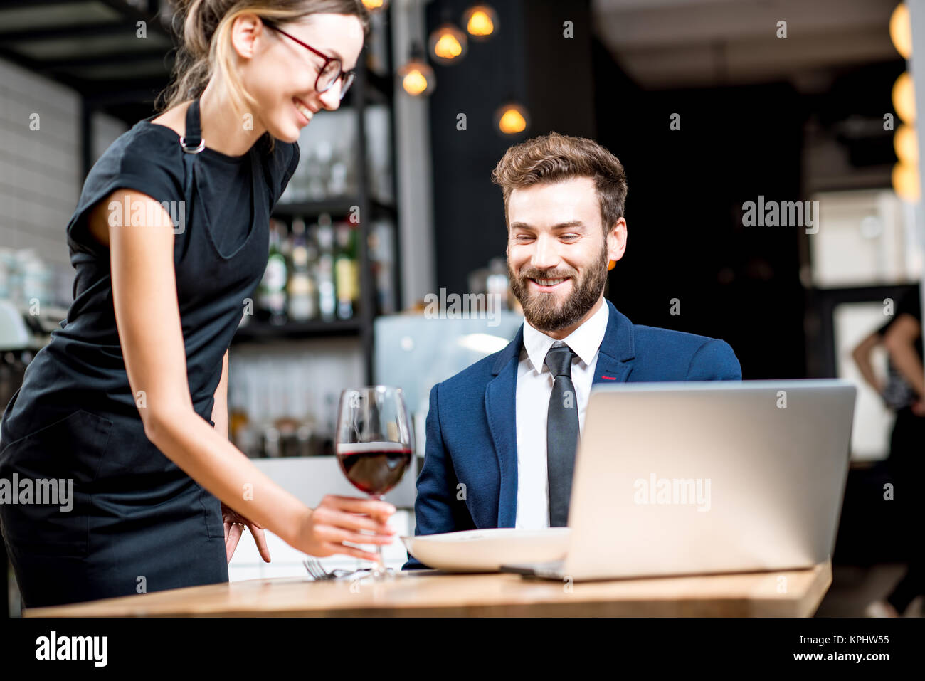 Geschäftsmann mit Kellnerin im Restaurant Stockfoto