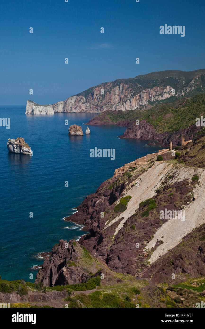 Italien, Sardinien, Nebida. Küste von Scoglio Pan di Zucchero Inselchen und Ruinen von Laveria Lamarmora Mining Complex. Stockfoto