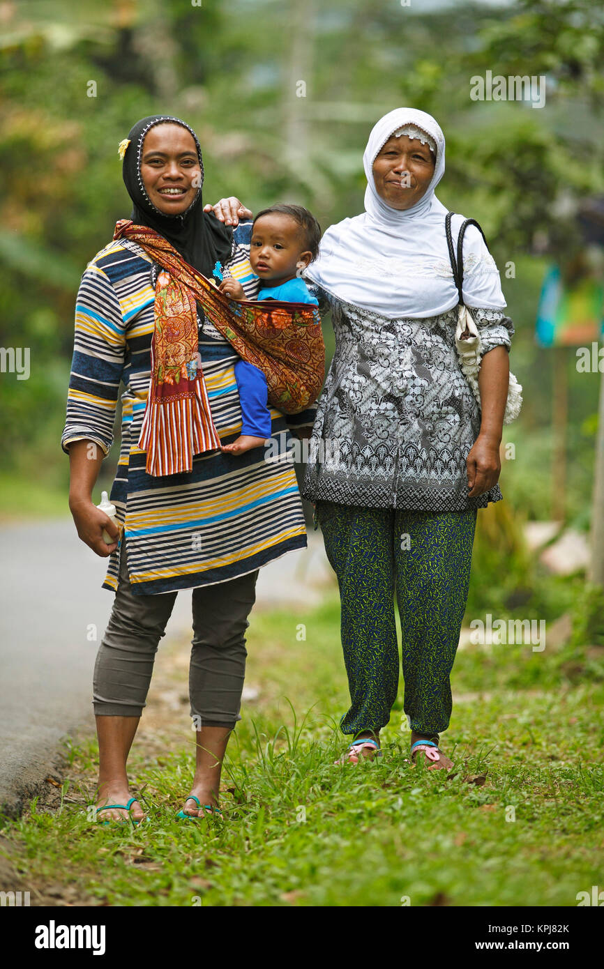 Muslimische Frauen, 37 und 45 Jahre alt, mit Kleinkind in Sling, Losari Dorf, Magelang, Java, Indonesien Stockfoto