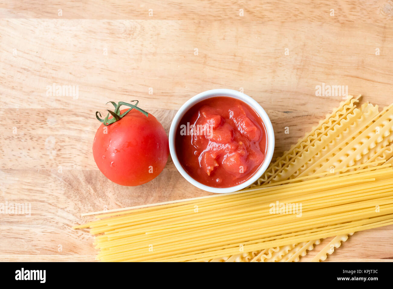 Trockene Spaghetti, frische Tomaten und Tomatensauce, Ansicht von oben, Raum für Text. Zutaten für italienische Pasta essen, Holz- Hintergrund. Stockfoto