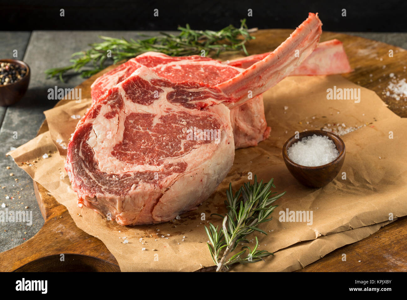 Rohe rote Gras gefüttert Tomahawk Steaks mit Rosmarin Stockfoto