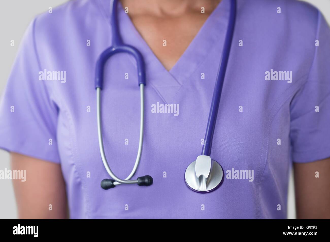 Ärztin in lila Top mit Stethoskop, aus der Nähe. Stockfoto
