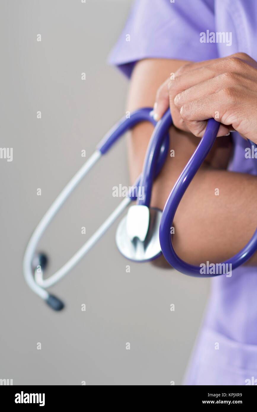 Ärztin holding Stethoskop, die Arme verschränkt. Stockfoto