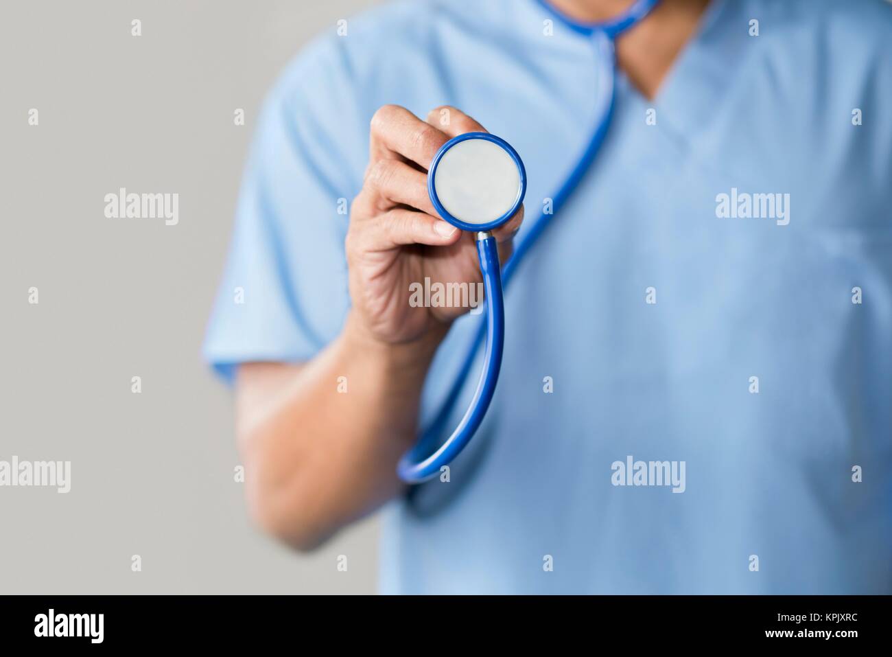 Männlicher Arzt in blauer Uniform mit Stethoskop. Stockfoto