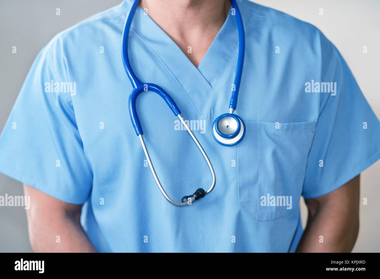 Männlicher Arzt in blauer Uniform mit Stethoskop. Stockfoto