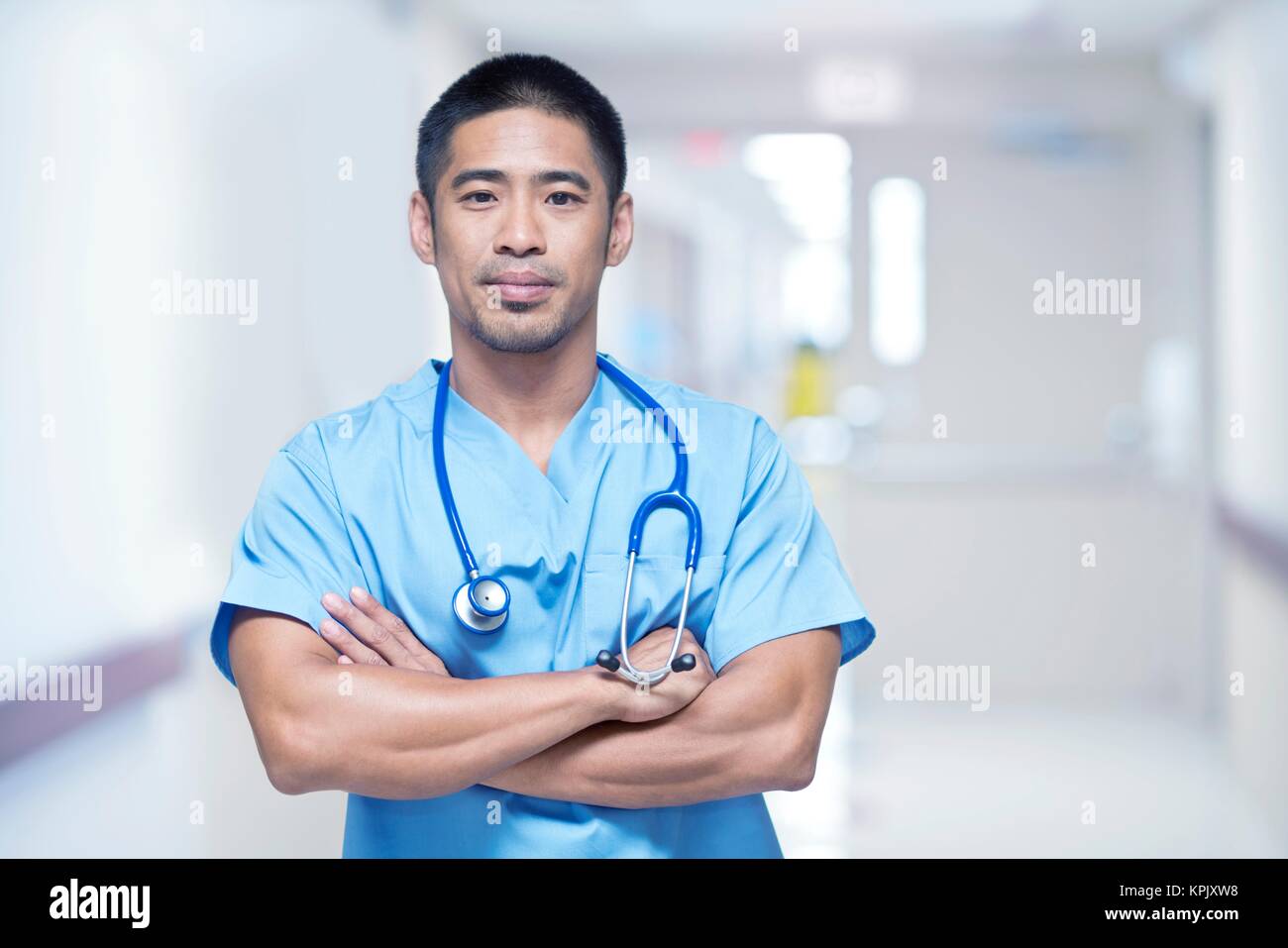 Männlicher Arzt im Krankenhaus mit verschränkten Armen, Portrait. Stockfoto