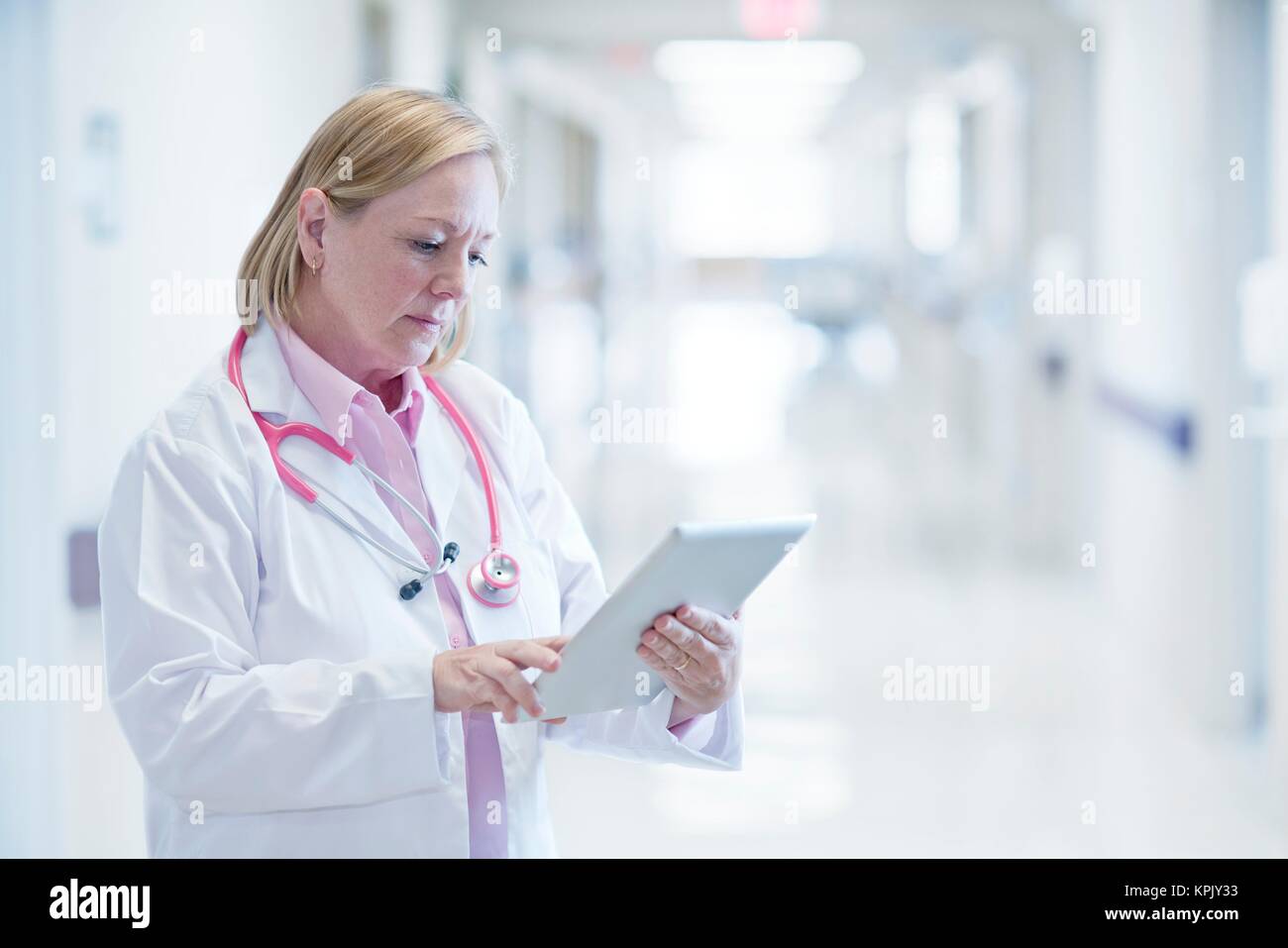 Reife Krankenschwester mit digitalen Tablet im Krankenhaus. Stockfoto